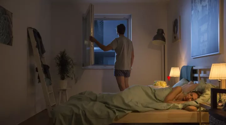 Mann am offenen Fenster Frau im Bett